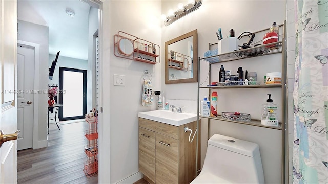 bathroom featuring hardwood / wood-style flooring, vanity, and toilet