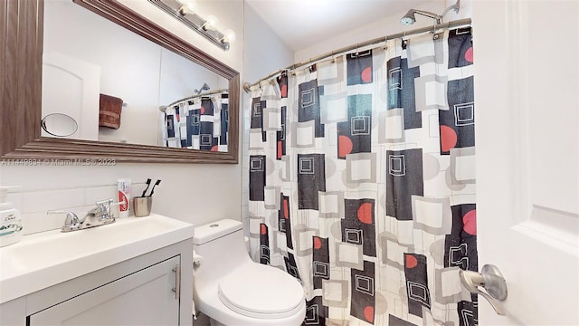 bathroom with toilet, vanity, and curtained shower