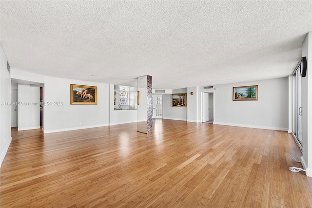 unfurnished living room featuring light hardwood / wood-style flooring and a textured ceiling