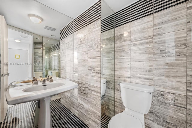 bathroom with tile walls and toilet