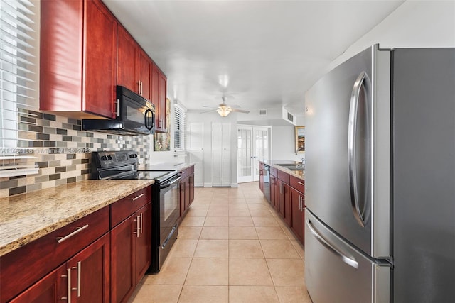 kitchen featuring light stone countertops, backsplash, ceiling fan, black appliances, and light tile floors