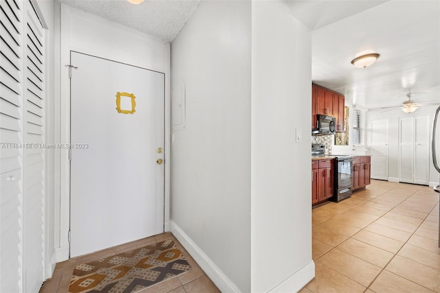 tiled entryway featuring ceiling fan and a textured ceiling