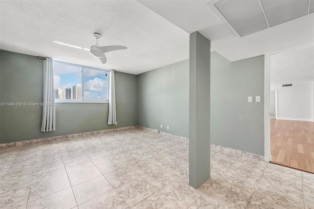 unfurnished room with a textured ceiling, ceiling fan, and light tile floors