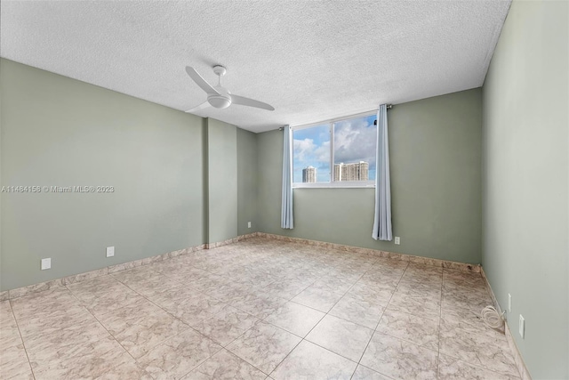 tiled spare room with a textured ceiling and ceiling fan