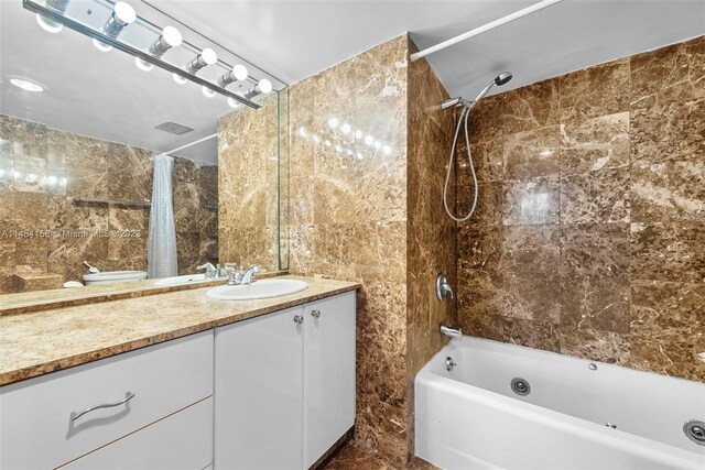 bathroom featuring tile floors, tile walls, large vanity, and shower / tub combo with curtain