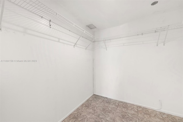 walk in closet featuring light tile floors