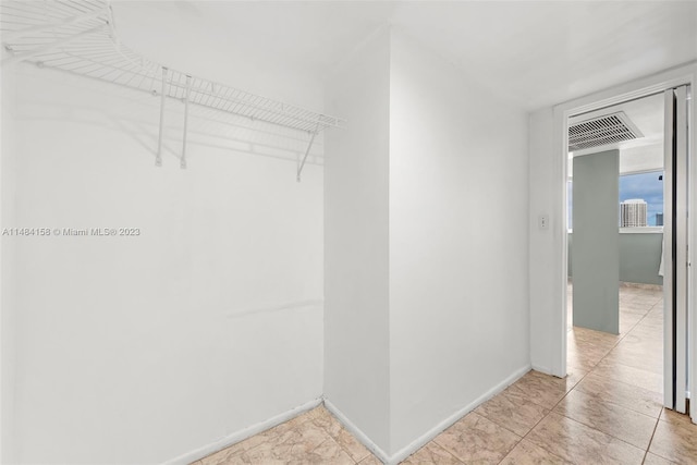 walk in closet featuring light tile floors