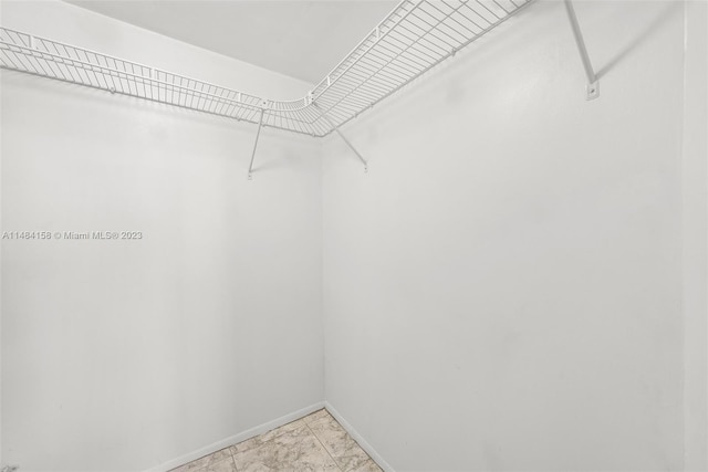 walk in closet featuring light tile flooring