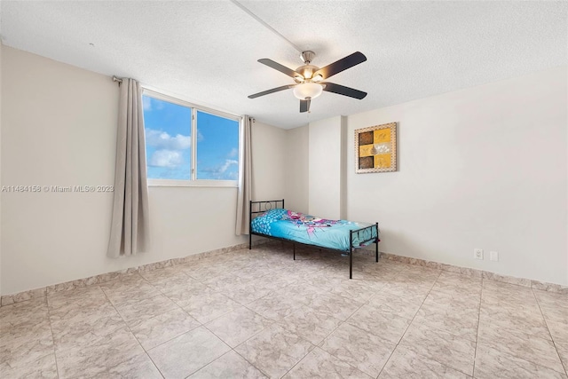 tiled bedroom with ceiling fan and a textured ceiling