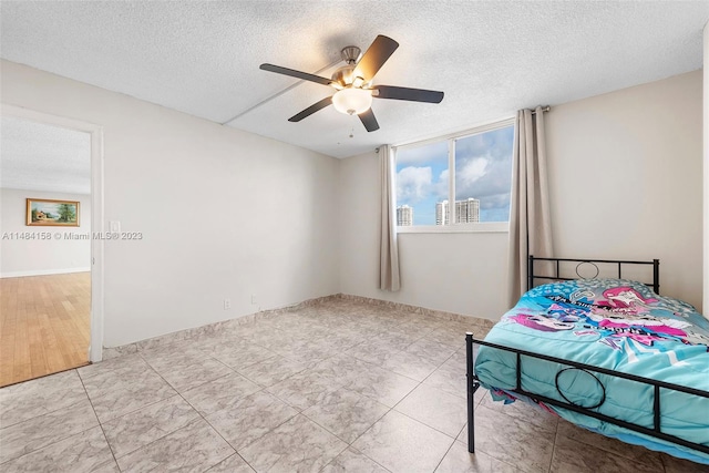 unfurnished bedroom with a textured ceiling, ceiling fan, and light tile floors