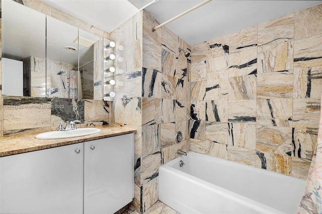 bathroom with tiled shower / bath combo, oversized vanity, and tile walls