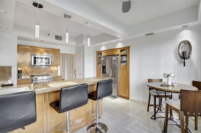 kitchen featuring backsplash, hanging light fixtures, light parquet floors, and high end appliances