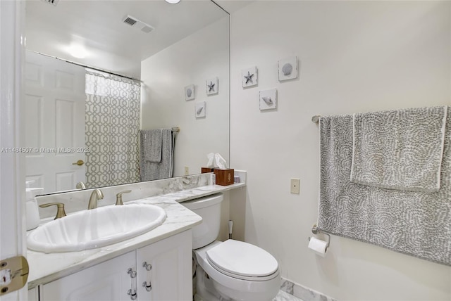 bathroom with toilet and vanity with extensive cabinet space