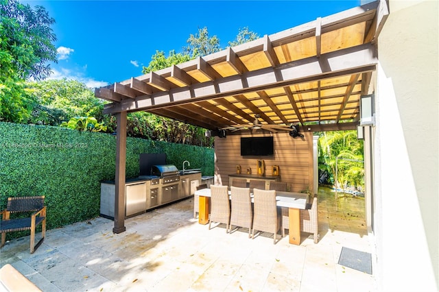 view of patio / terrace with a grill, ceiling fan, a pergola, and exterior kitchen