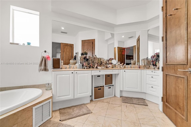 bathroom featuring a relaxing tiled bath, large vanity, and tile floors