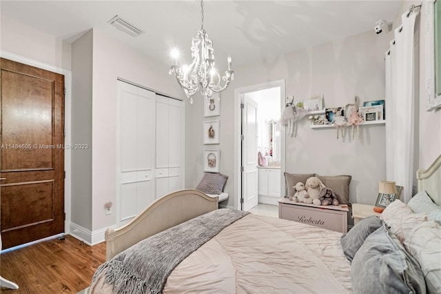 bedroom featuring a closet, a chandelier, and light wood-type flooring