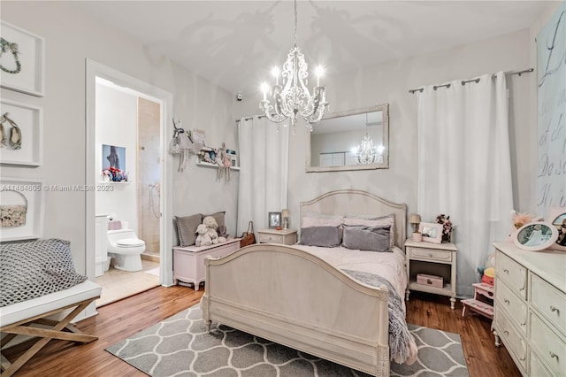 bedroom with a notable chandelier, ensuite bath, and dark wood-type flooring