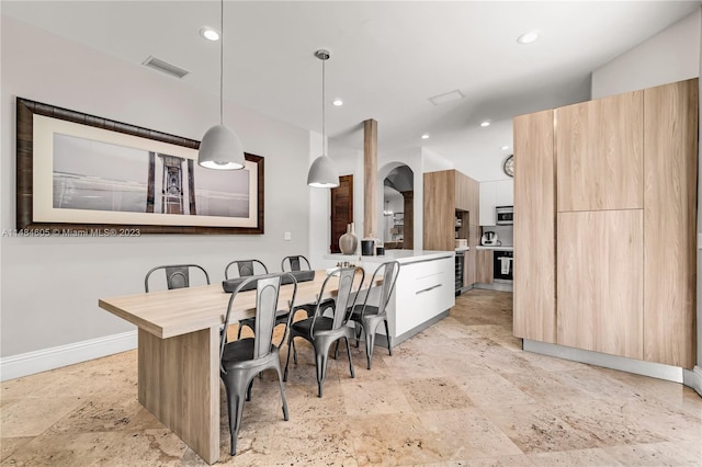 tiled dining space featuring vaulted ceiling