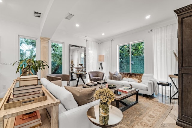 living room with crown molding, a healthy amount of sunlight, and ornate columns