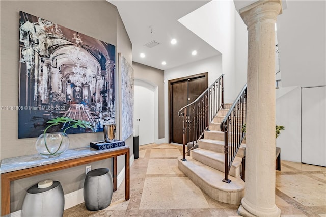 entrance foyer featuring decorative columns and light tile floors