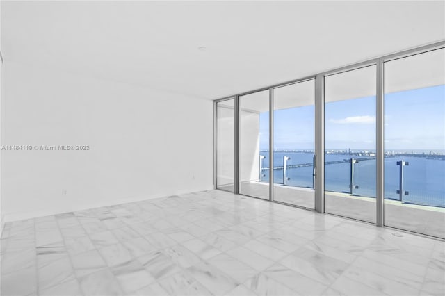 empty room featuring expansive windows and a water view