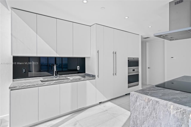 kitchen with extractor fan, black electric cooktop, white cabinets, stainless steel double oven, and backsplash