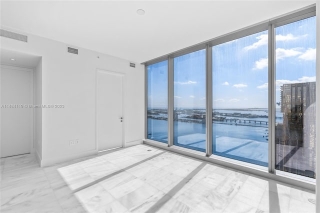 empty room featuring floor to ceiling windows and a water view