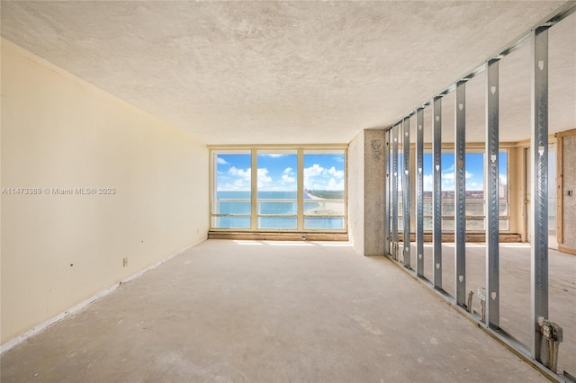 unfurnished room with a textured ceiling and concrete flooring