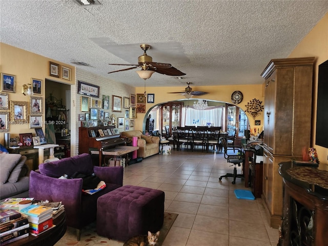 living room featuring a textured ceiling, ceiling fan, and tile patterned floors