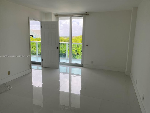 unfurnished room featuring plenty of natural light and light tile flooring