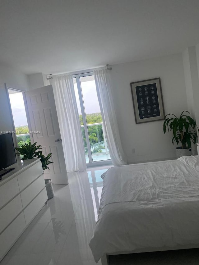 bedroom featuring access to exterior, light tile floors, and multiple windows