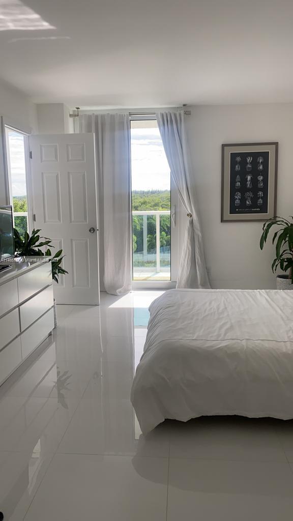 bedroom with multiple windows and light tile floors