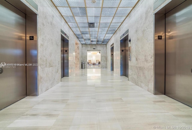 hall featuring light tile floors and elevator