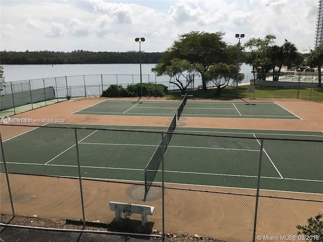 view of tennis court featuring a water view