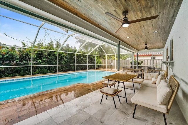 view of swimming pool featuring glass enclosure, an outdoor living space, ceiling fan, and a patio