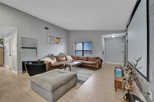 living room featuring lofted ceiling and light wood-type flooring