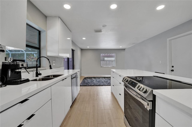 kitchen featuring white cabinets, light hardwood / wood-style flooring, sink, and stainless steel appliances