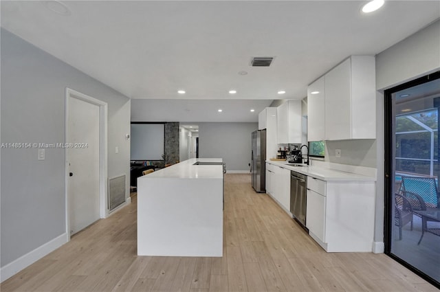 kitchen featuring white cabinets, light hardwood / wood-style floors, sink, and stainless steel appliances