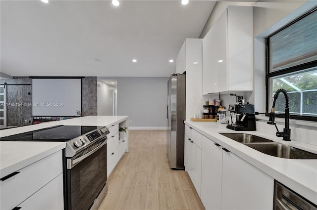 kitchen featuring light hardwood / wood-style flooring, electric stove, white cabinetry, and sink