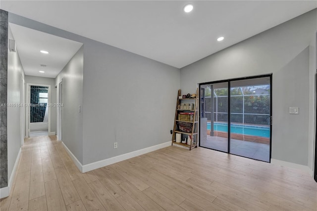 empty room with lofted ceiling and light wood-type flooring