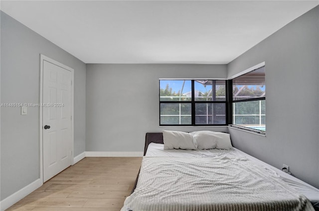 bedroom with multiple windows and light hardwood / wood-style flooring