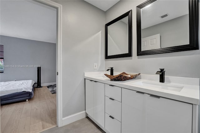 bathroom with hardwood / wood-style floors and dual vanity