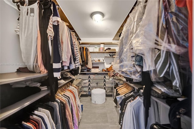 walk in closet featuring light tile flooring