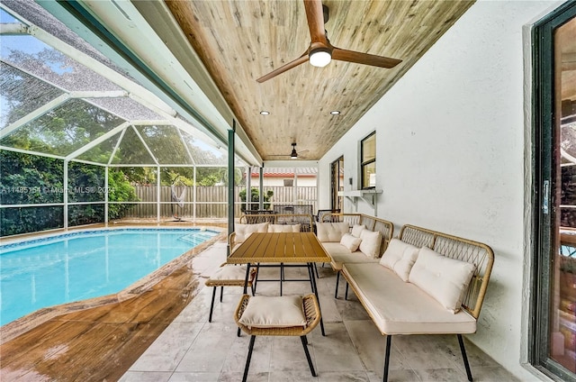 view of swimming pool featuring an outdoor living space, a patio area, ceiling fan, and a lanai