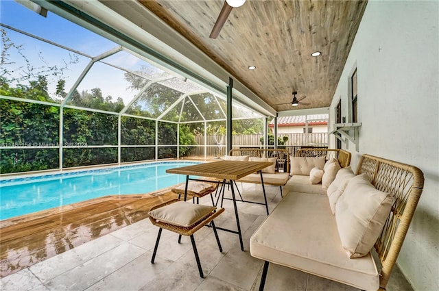 view of swimming pool featuring glass enclosure, an outdoor hangout area, ceiling fan, and a patio