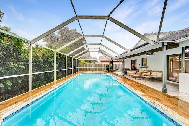 view of swimming pool with a patio, an outdoor living space, ceiling fan, and glass enclosure