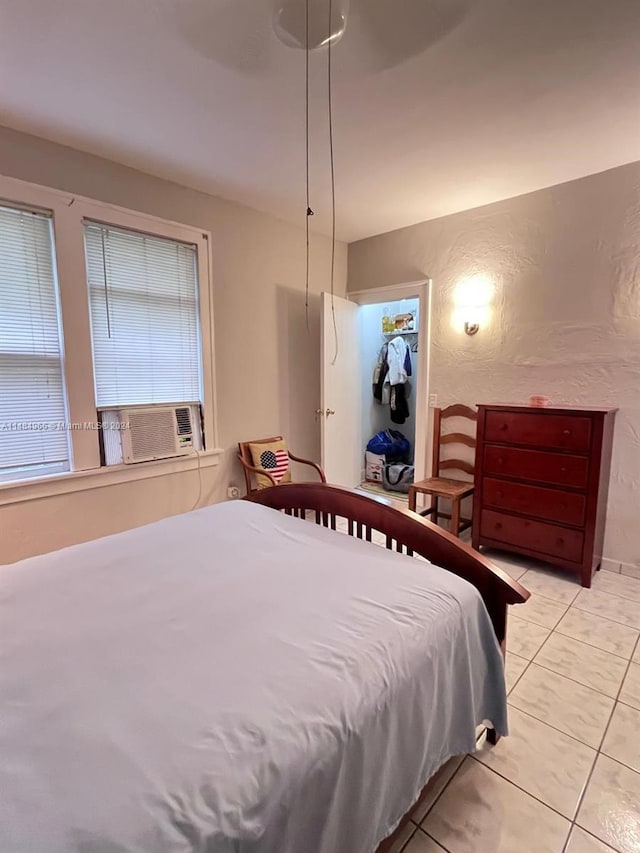 tiled bedroom with cooling unit, a closet, and ceiling fan