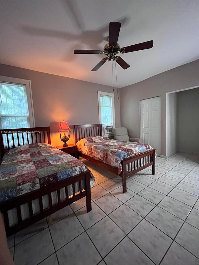 tiled bedroom featuring ceiling fan and a closet