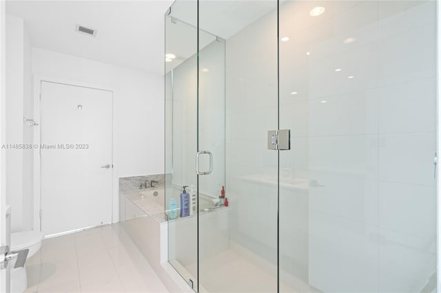 bathroom with shower with separate bathtub, toilet, and tile floors