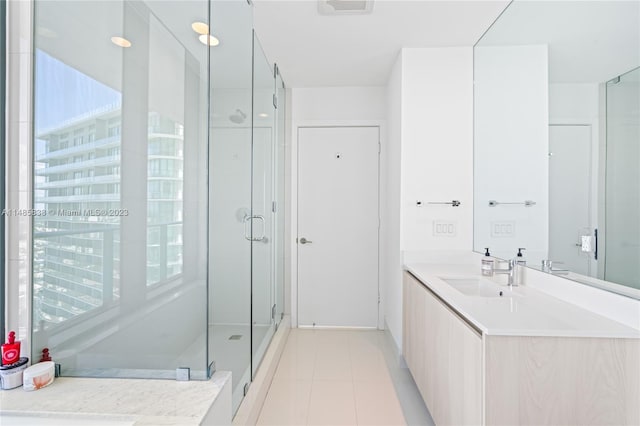 bathroom with a shower with door, tile flooring, and vanity with extensive cabinet space